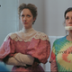 A woman (Judy Greer) in a frilly, old-fashioned gown looks irritated next to a woman (Melanie Lynskey) wearing a tie-dye shirt with a bar of soap in her mouth in Lady of the Manor.